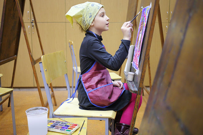 budding watercolor artist intently concentrating on her painting